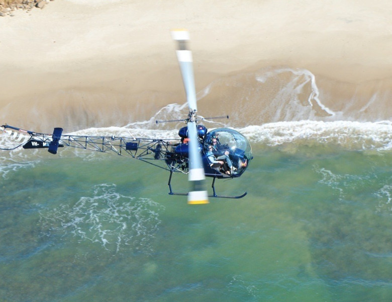 Helicopter flying over water. Photo Credit: Air T & G Helicopters