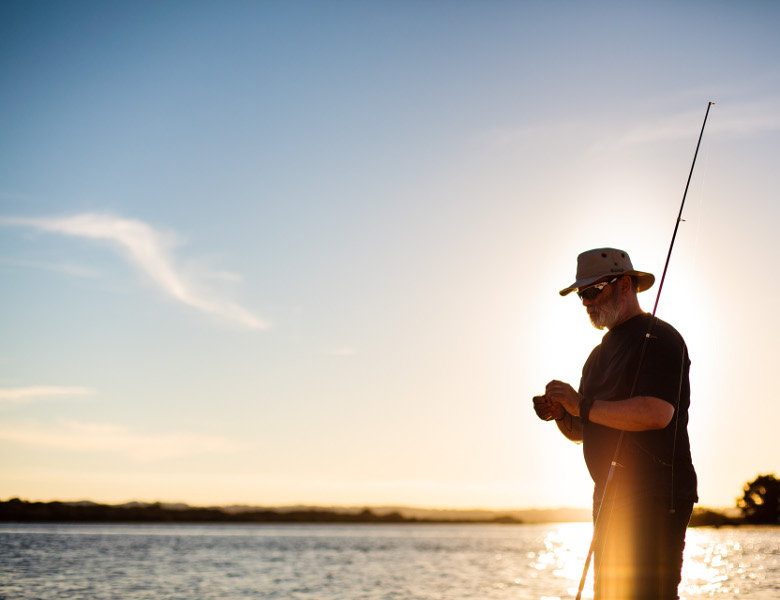 Man Fishing with sunset behind him